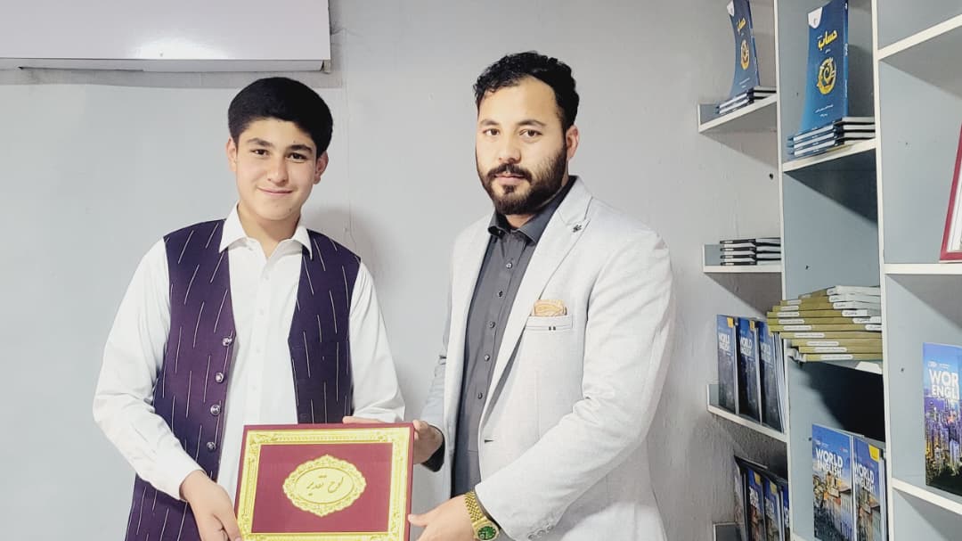 ZAAC teacher presenting a certificate to a student